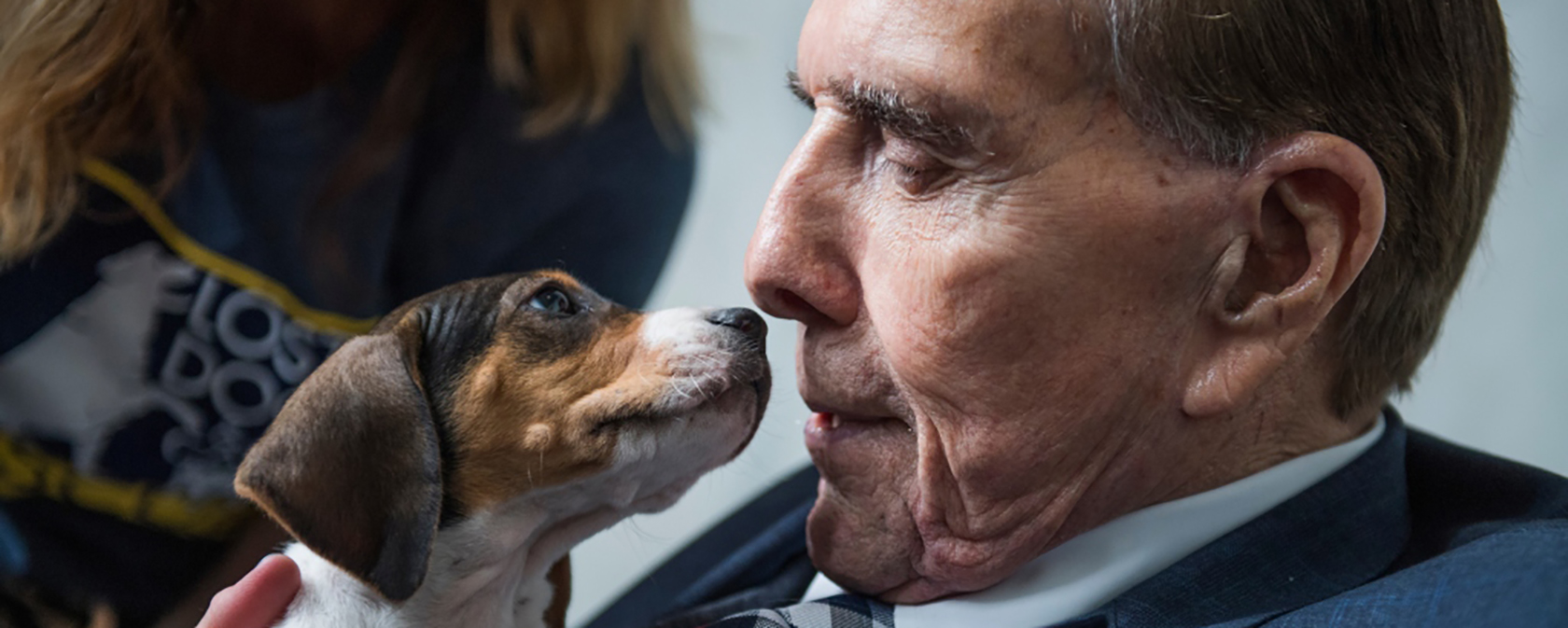 Senator Dole with a beagle mix puppy at an adoption event.